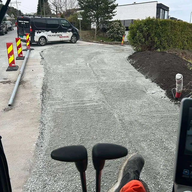 Nyplanert grusvei med veiarbeidsskilt og arbeidsbil fra Franzen Maskin.